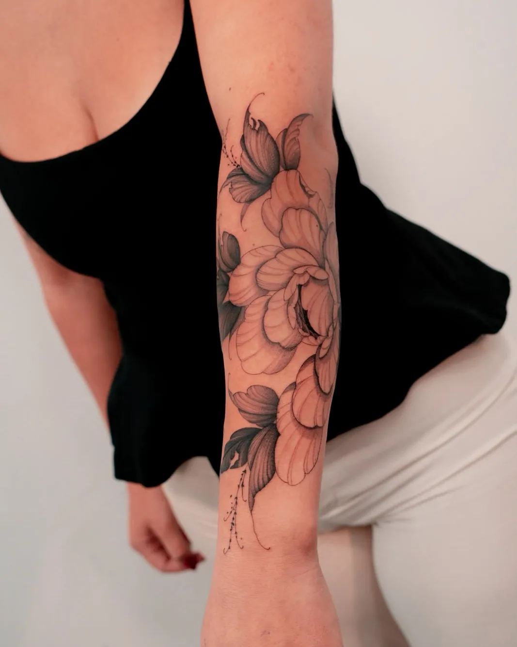 Tatuagem botânica de peónia e lírio no antebraço