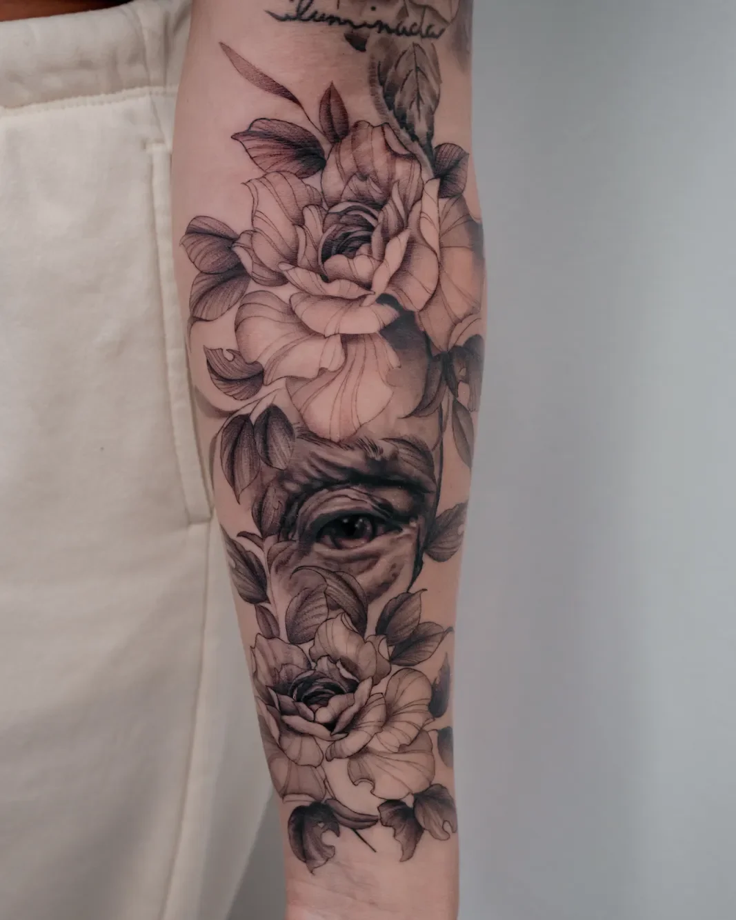 Botânico roses and hidden eye tattoo on the forearm
