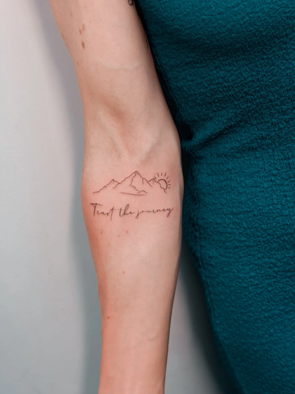 Fine line mountains, sun and lettering tattoo by Hugo Gonzalez