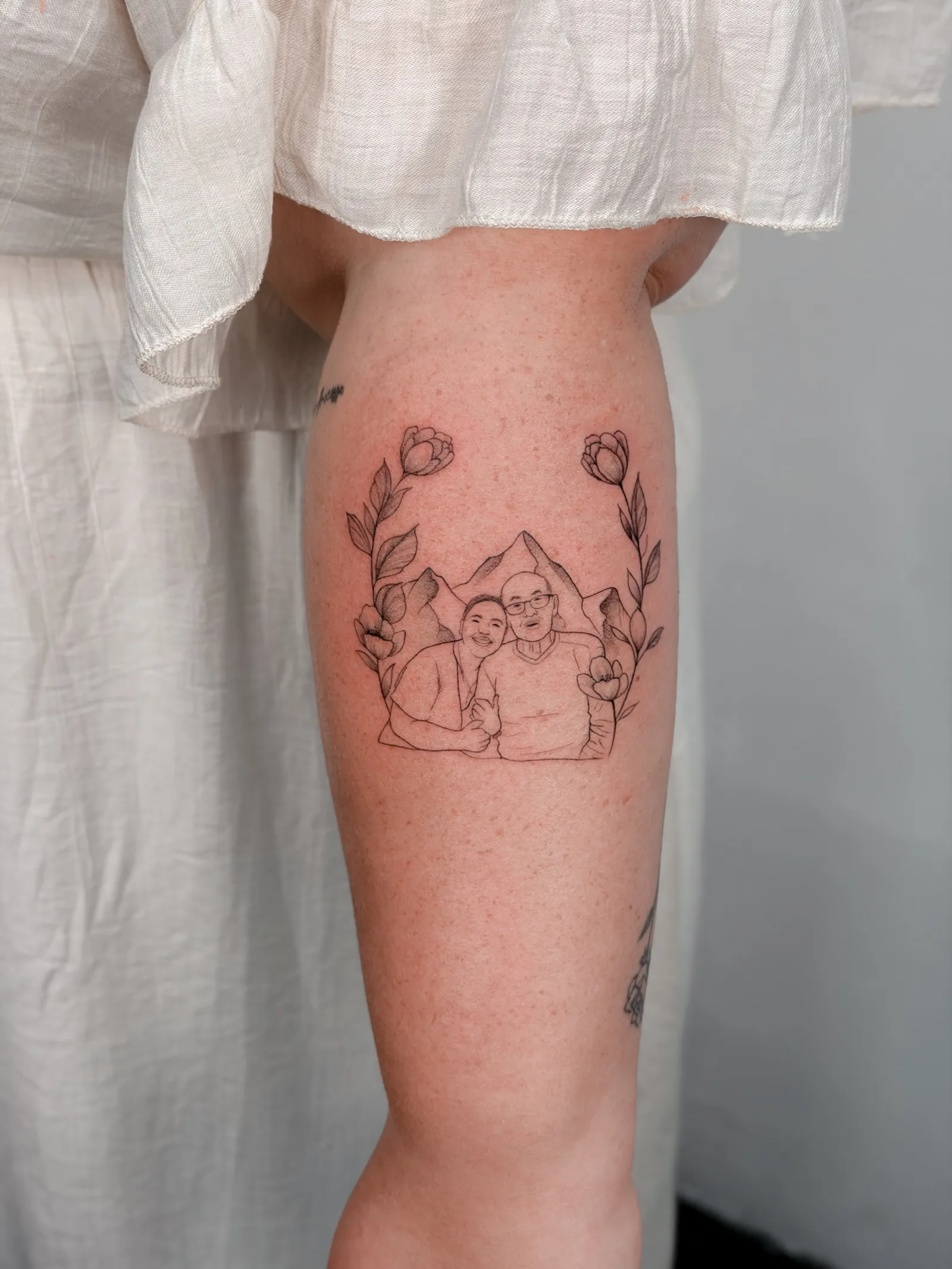 Fine line family portrait with flowers and mountains by Hugo Gonzalez